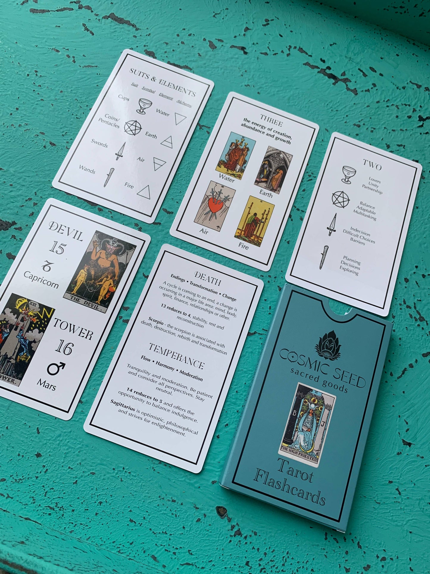 Tarot flashcards from Cosmic Seed on a teal surface