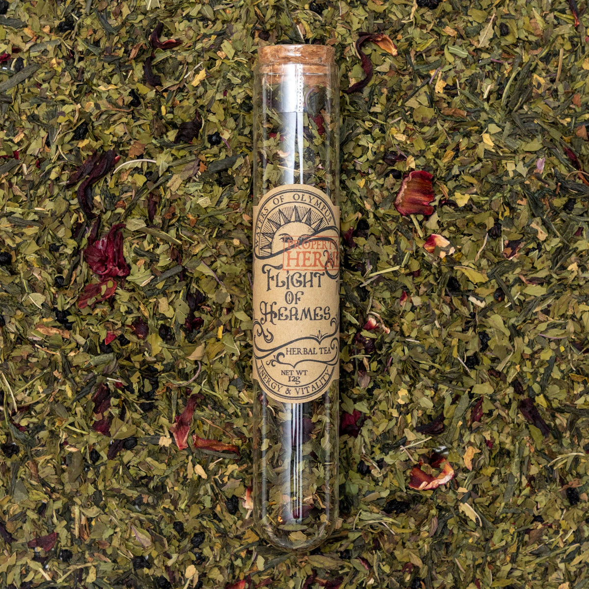 Herbal tea in a glass tube labeled 'Flight of Hermes' on a bed of dried herbs.