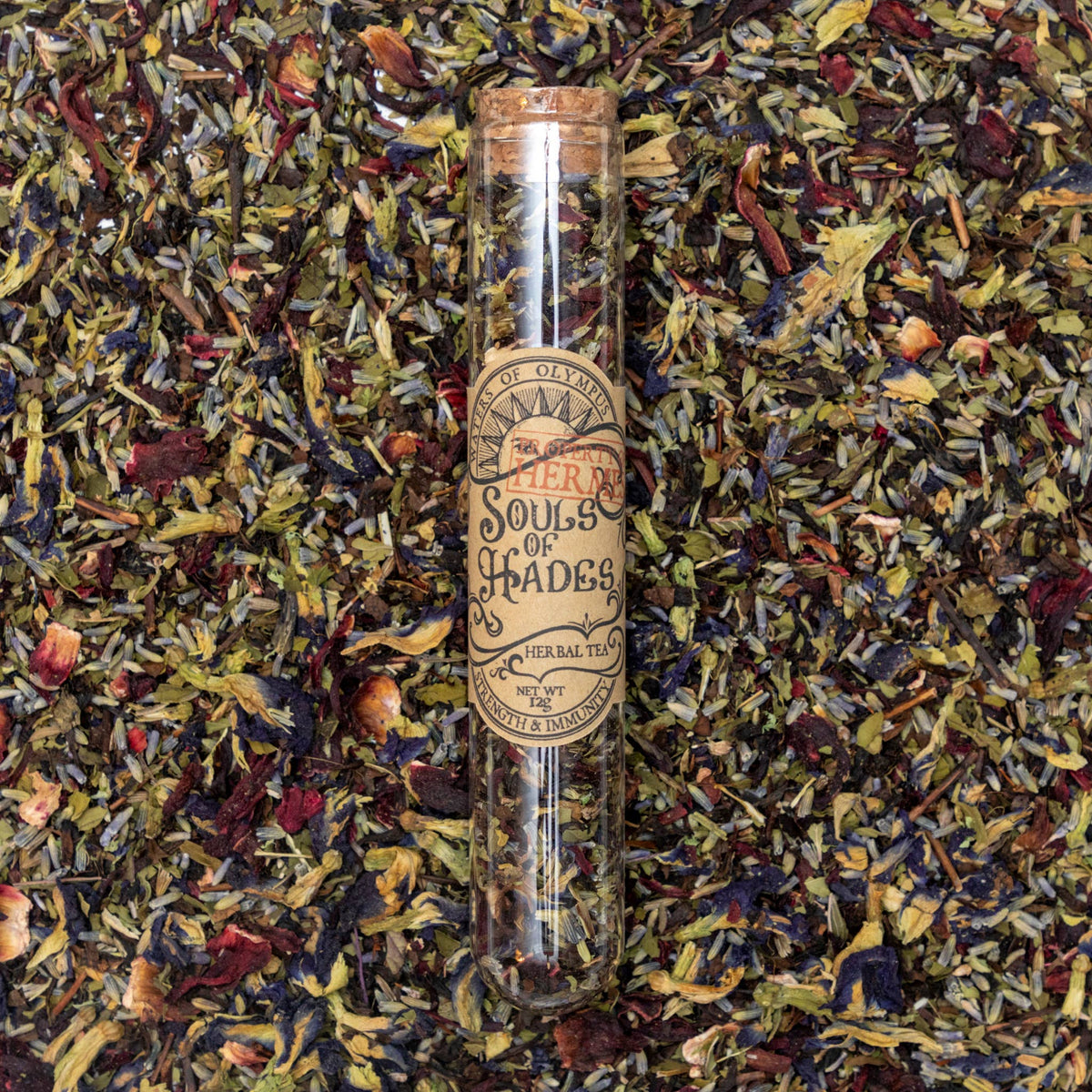 Tea leaves with a glass tube labeled 'Spirits of Olympus' on a bed of tea leaves.