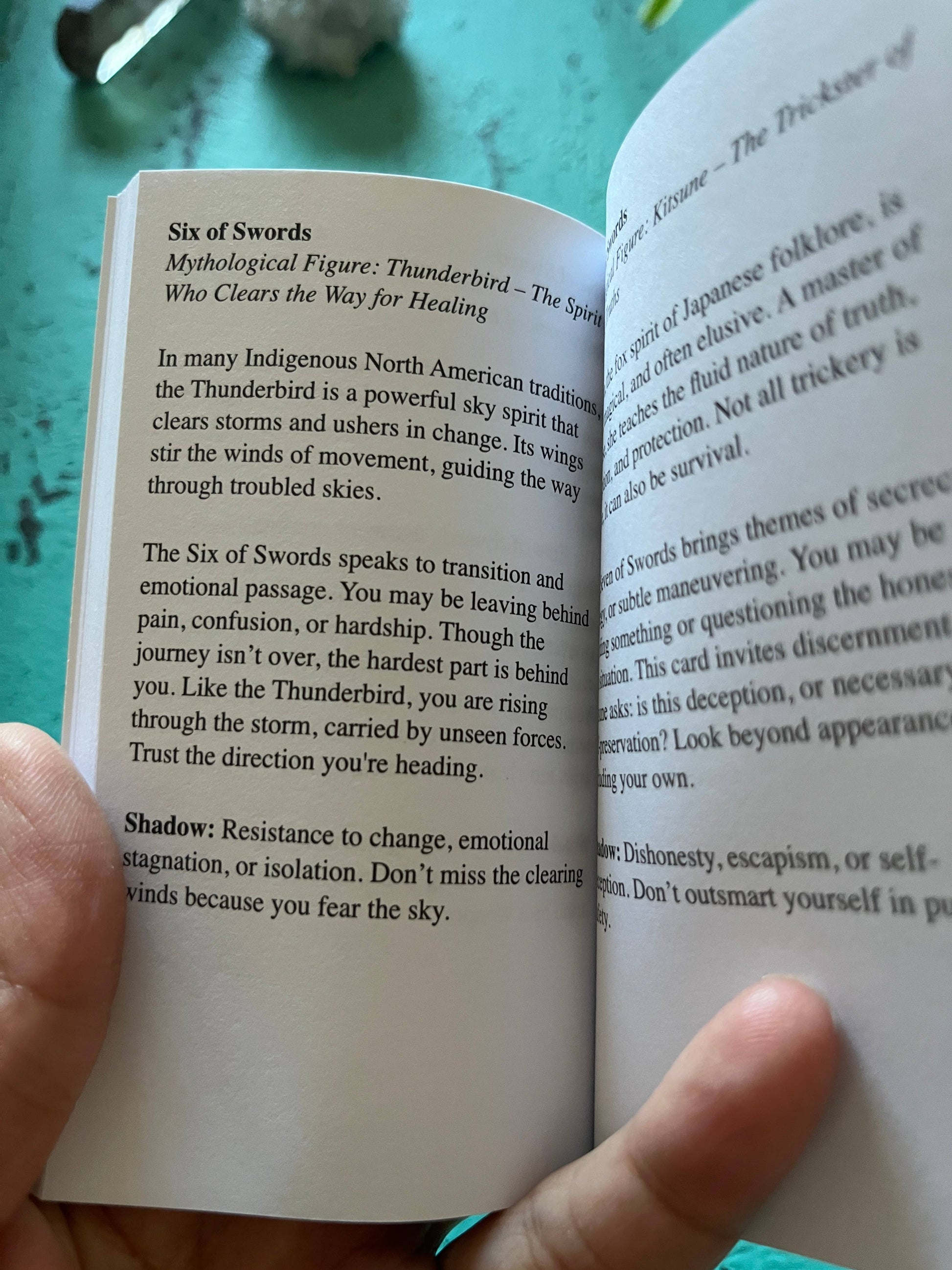 Open book with text on a teal surface