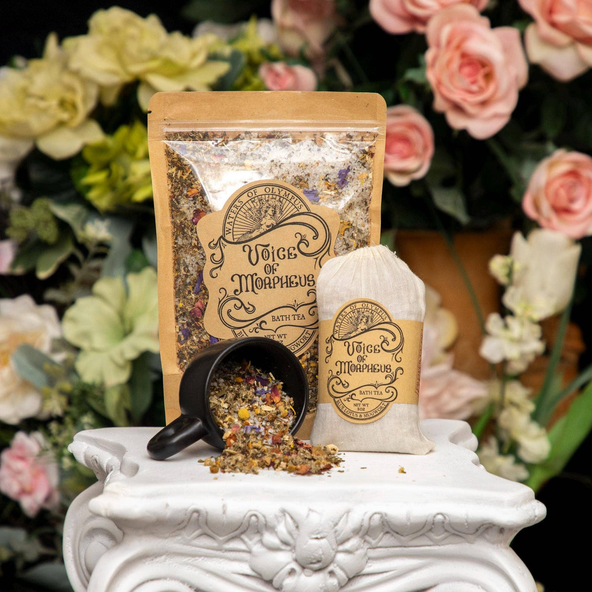 Bath salts packaging with a black mug on a decorative stand with flowers in the background