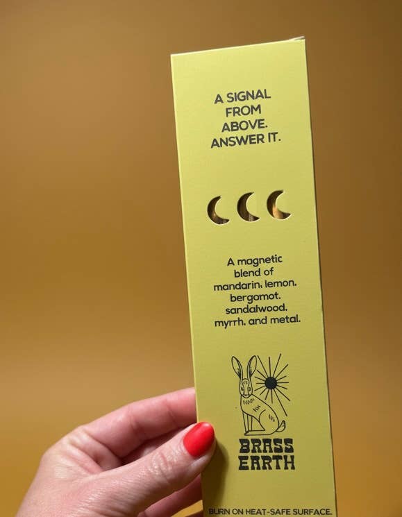 Yellow card with text and moon symbols held by a hand against a yellow background
