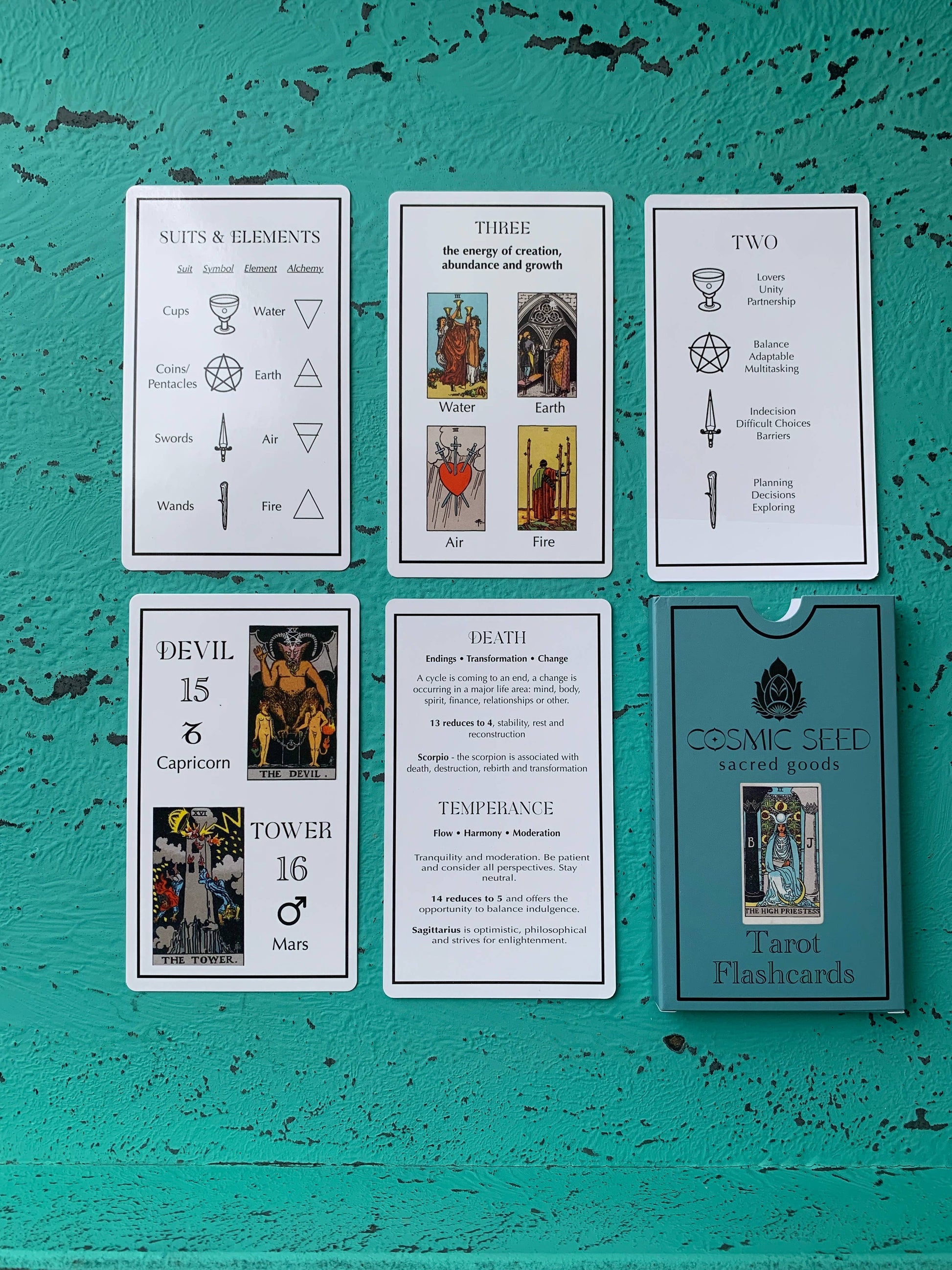 Set of instructional tarot cards on a textured teal surface with 'Cosmic Seed' branding.