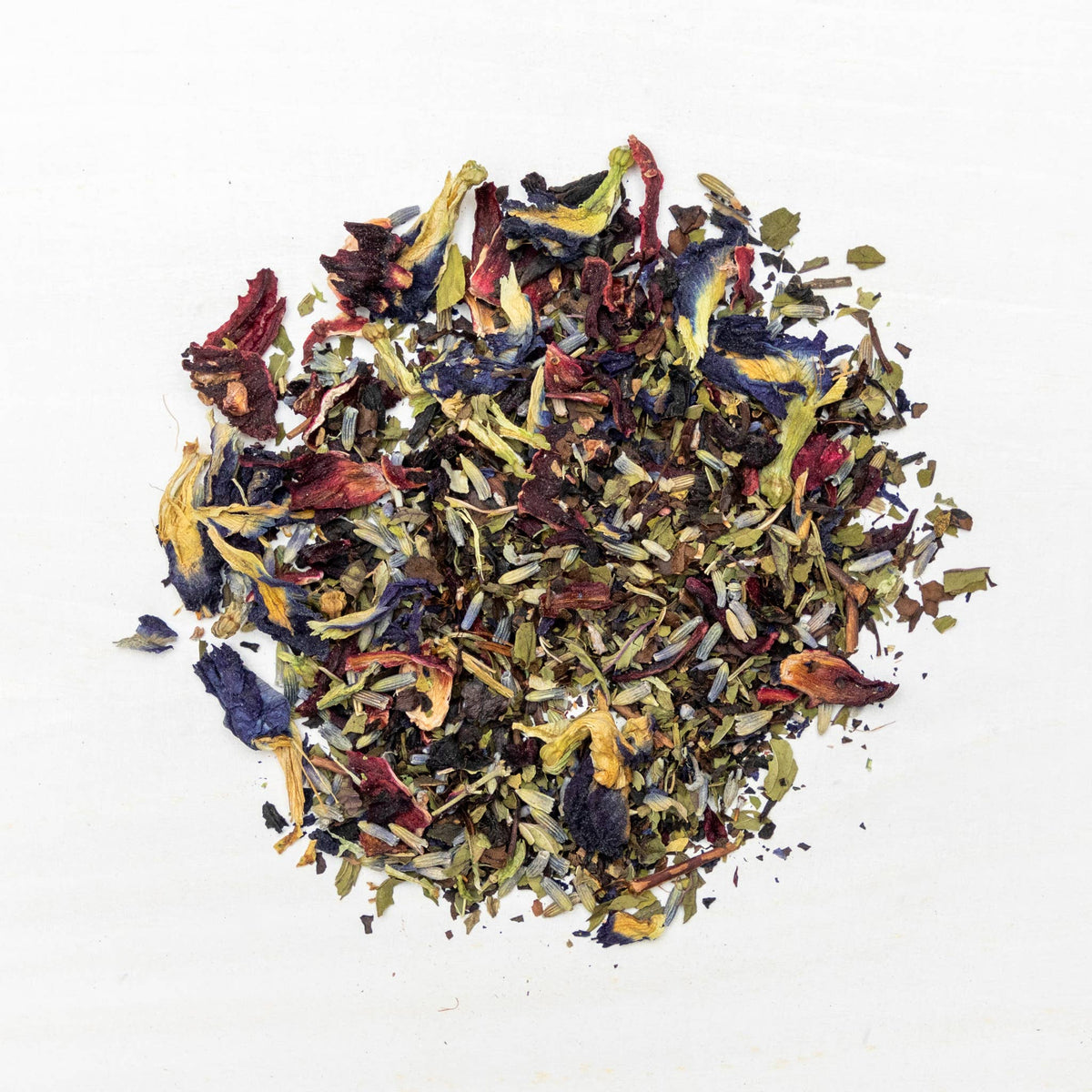 Colorful assortment of dried tea leaves on a white background