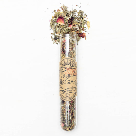 Clear glass tube with dried herbs and flowers on a white background
