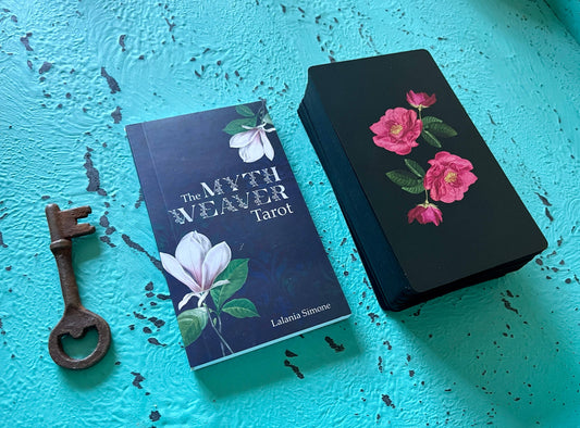 Tarot book titled 'The Myth Weaver Tarot' with a decorative box and key on a blue textured surface