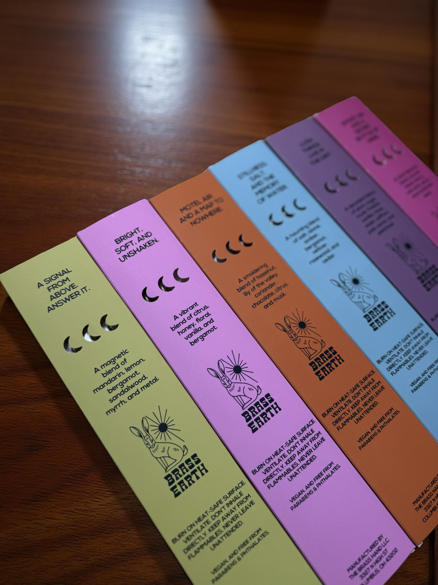Set of incense boxes with text and graphics on a wooden surface